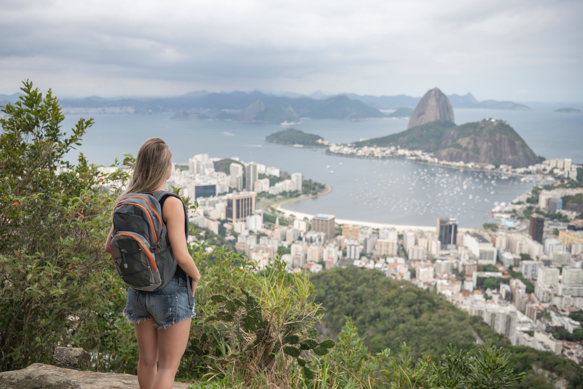Young woman wearing rucksack and taking in views of Sugar Loaf Mountain